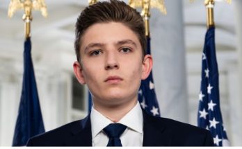 Barron Trump standing beside family