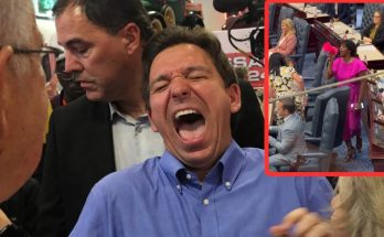 man laughing energetically in a crowded event with a woman speaking passionately