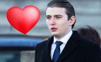 young man in suit with heart emoji, urban background