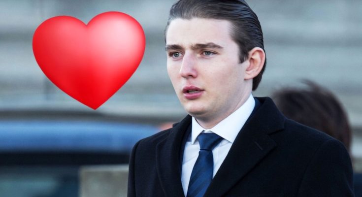 young man in suit with heart emoji, urban background