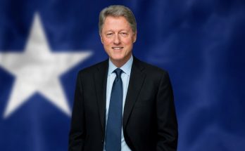 man in suit with star backdrop, smiling confidently