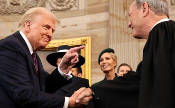 leaders exchange smiles and handshake in formal setting