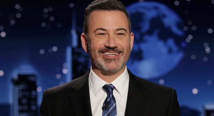 smiling host in suit with moonlit backdrop on talk show set