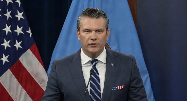 secretary of Defense Pete Hegseth speaking at Pentagon podium with American flag and blue