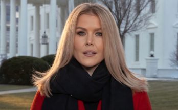 blonde woman in red coat and black scarf stands before White House columns with BREAKING