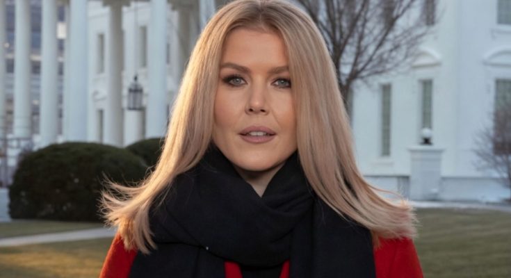blonde woman in red coat and black scarf stands before White House columns with BREAKING