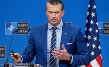 man in blue suit speaking at NATO press conference