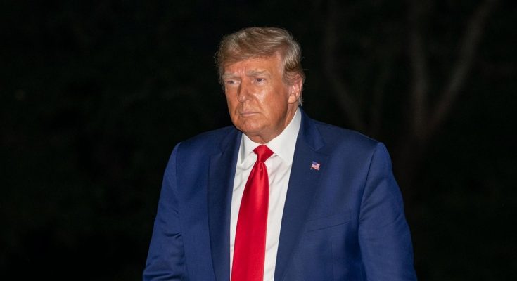 person in blue suit with red tie outdoors at night