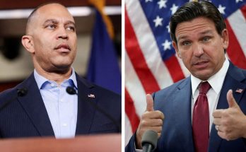 political leaders speaking at press conference with flags behind them