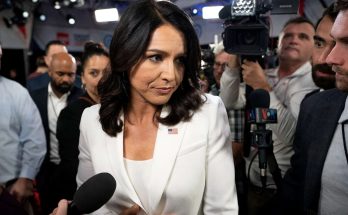 confident woman in white suit surrounded by press at event