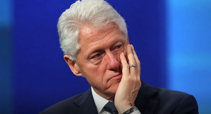 thoughtful man in suit on blue background, hand on face