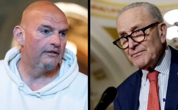 senator John Fetterman in white hoodie beside Senator Chuck Schumer at Capitol press