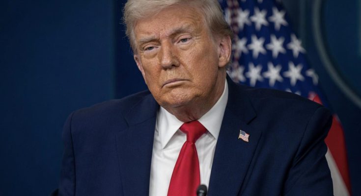 donald Trump at podium with stern expression, American flag behind him, headline about