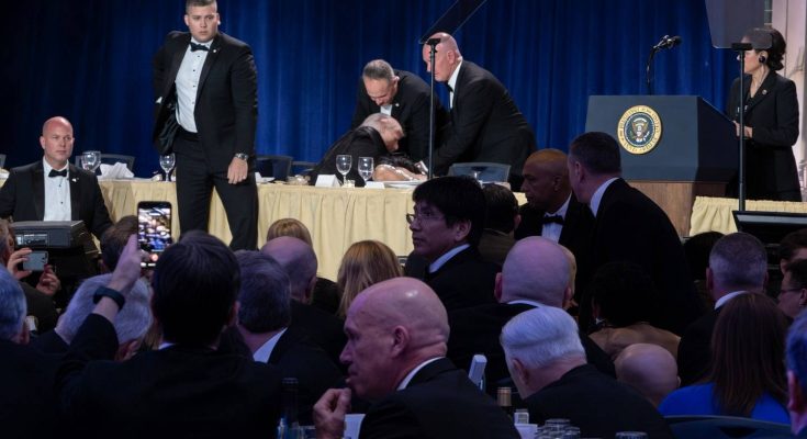 security personnel assist man at formal event with presidential seal