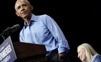 barack Obama stands at a podium with Spanberger campaign signage while a blonde woman