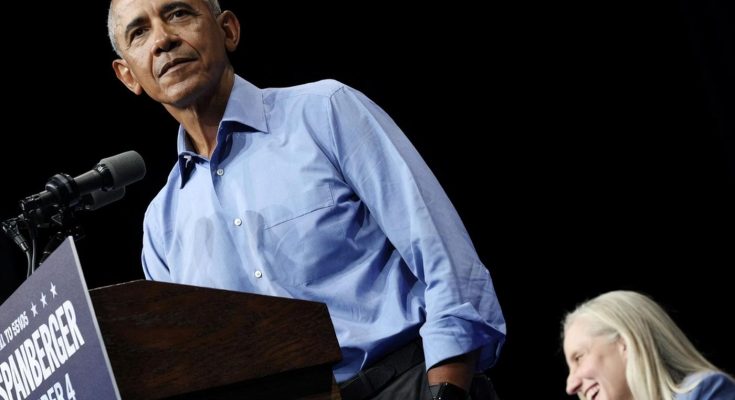 barack Obama stands at a podium with Spanberger campaign signage while a blonde woman