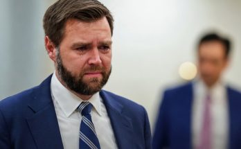 JD Vance crying in blue suit with striped tie, breaking news text overlay