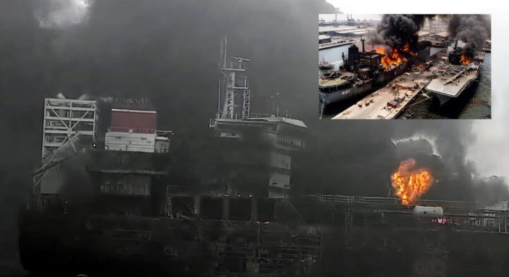 burning ship with thick smoke engulfing the port area