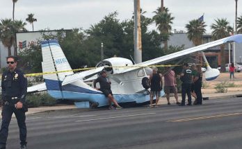 small aircraft crash lands on city street with police on site