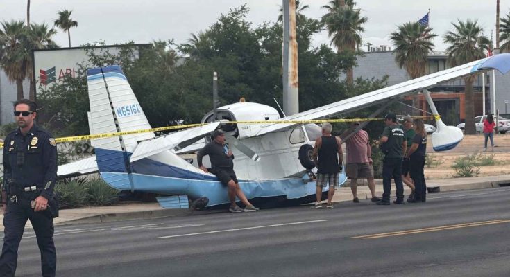 small aircraft crash lands on city street with police on site