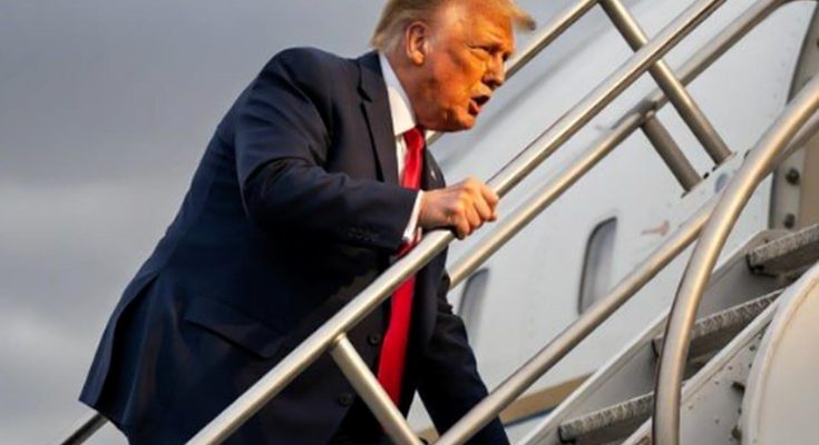 man in suit climbing airplane stairs under cloudy sky, focus on travel