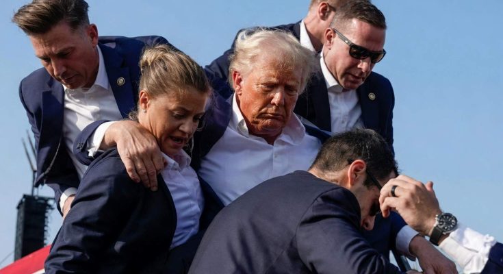 security personnel assist a man descending stairs at outdoor event