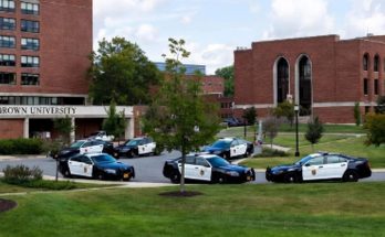 police cars parked at Brown University campus entrance, sunny day