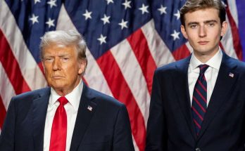 two men in suits with American flags in background
