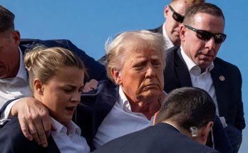 donald Trump surrounded by Secret Service agents with female agent in foreground during