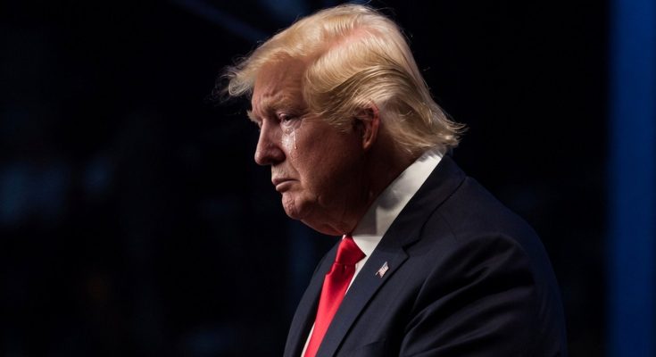serious man in suit with contemplative expression on stage