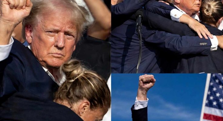 crowd gathers around speaker at political rally with raised fists