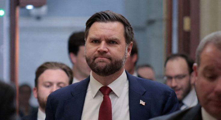 vice President JD Vance walks through Capitol hallway wearing navy suit and red tie after