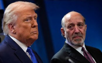 two prominent men in suits at a public event