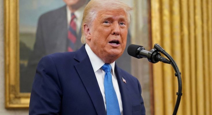 donald Trump speaking at podium with blue tie, portrait of George W. Bush visible behind