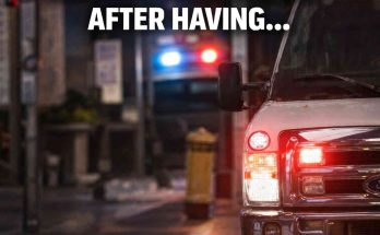 ambulance with flashing lights on city street at night