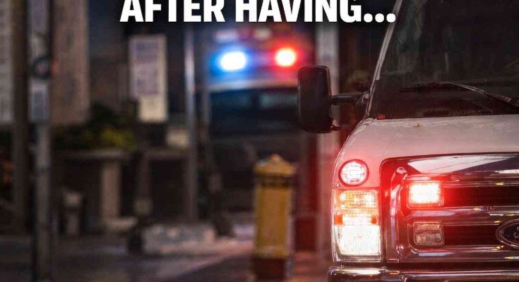 ambulance with flashing lights on city street at night