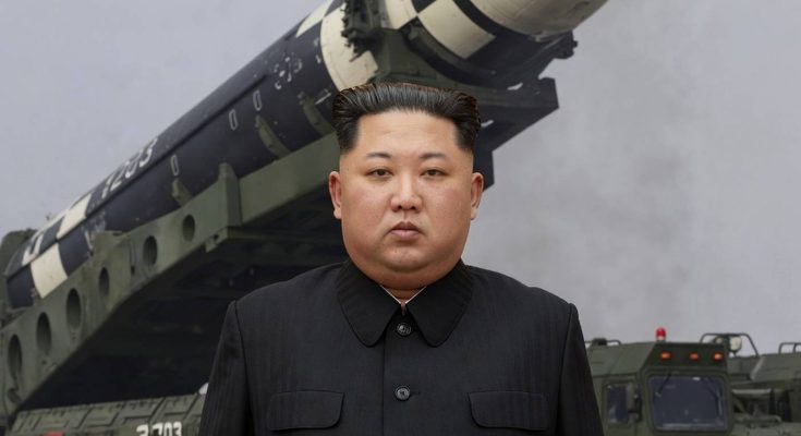 leader standing before military missile on transporter, foggy background
