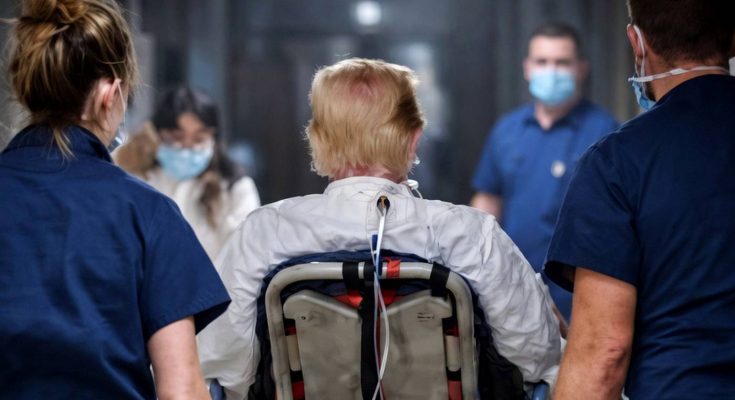 medical staff wheel a patient on a stretcher through a hospital hallway with breaking
