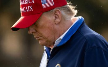 man in red cap with America slogan outdoors, thoughtful expression