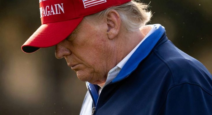 man in red cap with America slogan outdoors, thoughtful expression