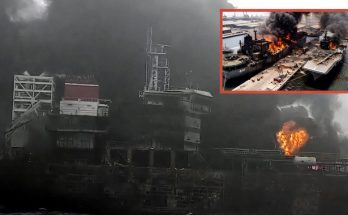 burning warship with thick smoke at shipyard, naval disaster unfolding