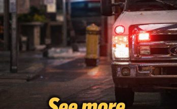 emergency vehicle with flashing red and blue lights on wet city street at night with bold