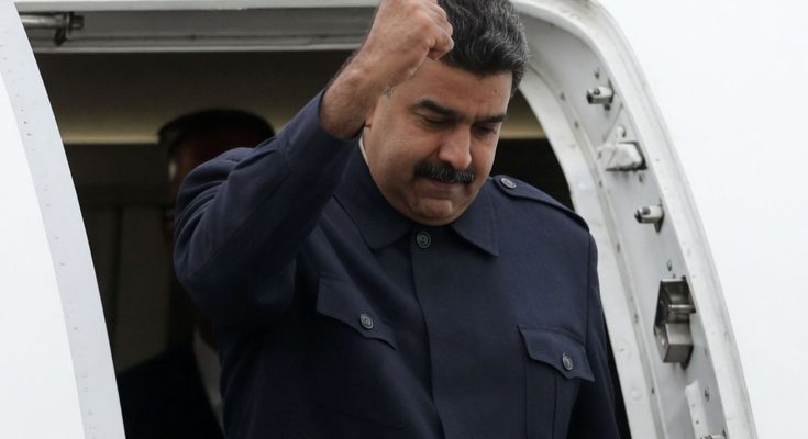 leader exits plane with raised fist in defiant gesture