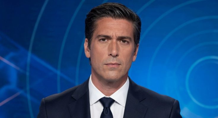 news anchor in dark suit with silver tie clip delivering breaking news in television