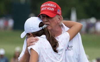 donald Trump in red MAGA cap embraces female golfer in white outfit on green course