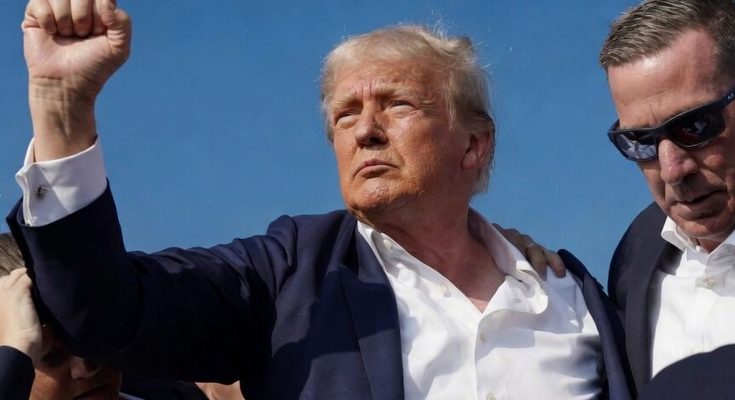 man raising fist confidently among security under clear sky