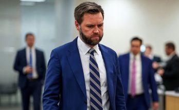 businessman in blue suit walking in office, serious expression
