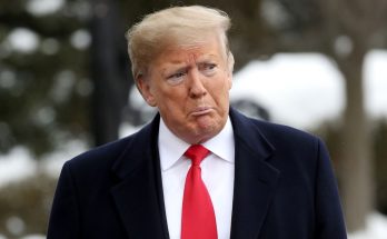 man in suit with red tie in an outdoor setting