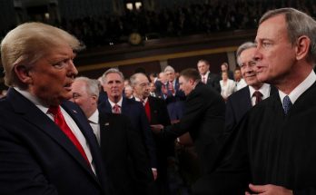 leaders shaking hands during formal event, serious expressions