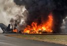 burning aircraft engulfed in flames on airport runway